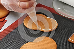 applying a layer of glaze to a confectionery product using a pastry bag. A row of gingerbread cookies on the kitchen