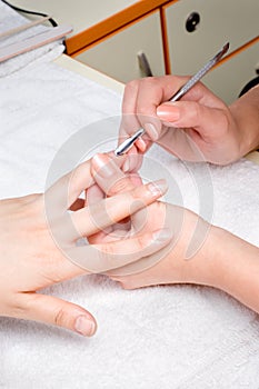 Applying manicure - cuticle cleaning photo