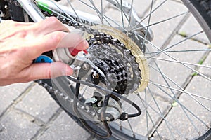 Applying oil on mountain bike chain. Man hands lubing bicycle chain. Technical expertise taking care Bicycle Shop