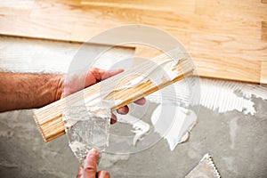 Applying of parquet glue on a floor plate