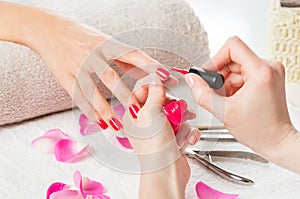 Applying pink nail polish photo