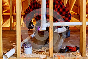 Applying plumber pipe drain and vent plumbing system at new home construction