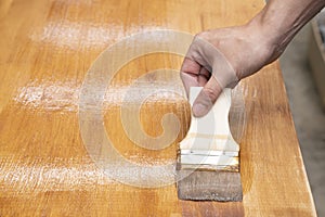 Applying protective varnish on a wooden furniture