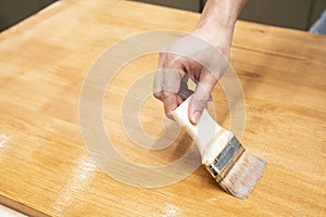 Applying protective varnish on a wooden furniture