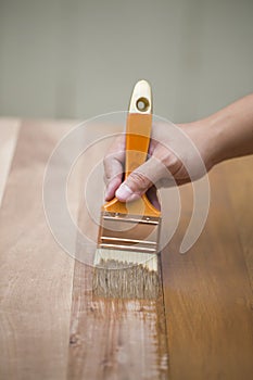 Applying protective varnish on wooden furniture