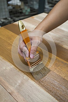 Applying protective varnish on a wooden furniture