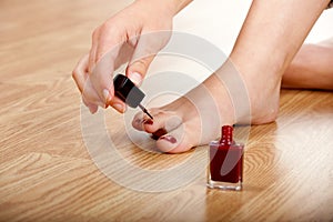 Applying red nail polish