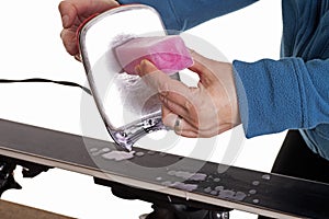 Applying ski wax to ski base