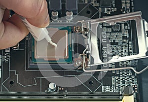 Applying thermal paste during CPU installation close up in the motherboard