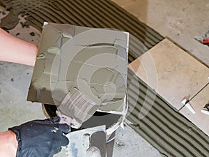 Applying thinset mortar on a tile. Apply the adhesive, closeup.