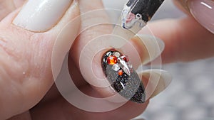 Applying a three-dimensional pattern with rhinestones and broths on the nail.