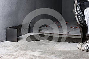 Applying tile glue to the floor using a tiling comb.