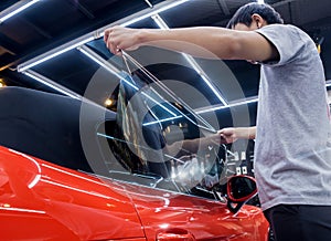 Applying tinting foil on a car window in a auto service photo