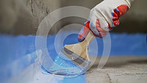 Applying a waterproofing mixture to the floor. Floor waterproofing in bathroom. Floor waterproofing in bathroom. Worker