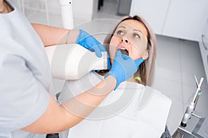 appointment with a dentist. Woman doctor dentist makes x-ray of teeth to the patient. The concept of dental treatment.