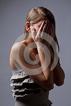 Apprehensive girl closed her eyes with her hands photo