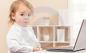 Apprehensive toddler girl using a laptop