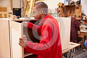 Apprentice Building Furniture In Carpentry Workshop