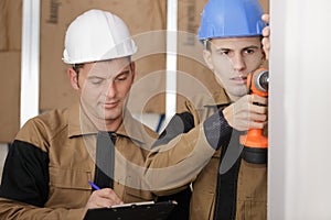 Apprentice drilling the wall