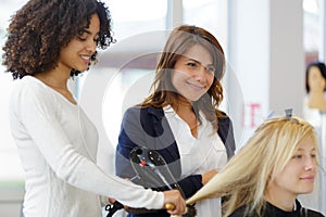 apprentice drying clients hair using blowdry