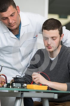 Apprentice in electronics doing voltage test
