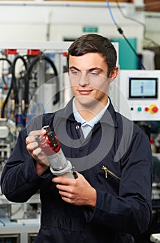 Apprentice Engineer Checking Component In Factory