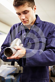 Apprentice Engineer Checking Component On Factory Floor