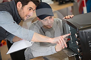 apprentice engineer learning how to repair oven