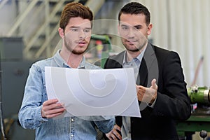 Apprentice engineer showing idea to mentor