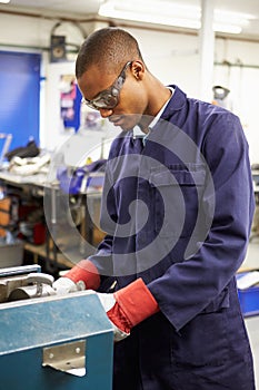 Apprentice Engineer Working On Factory Floor