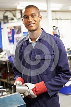 Apprentice Engineer Working On Factory Floor