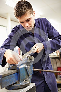 Apprentice Engineer Working On Factory Floor