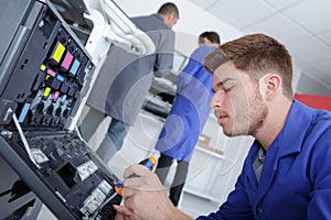 Apprentice fixing a printer