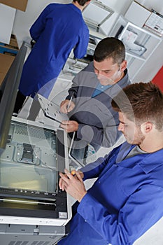 Apprentice fixing a printer