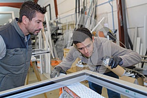 Apprentice glazier and mentor in factory workshop
