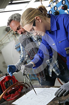 Apprentice with instructor in plumbery drawing plan