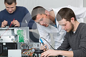 Apprentice male technician soldering lan switch router