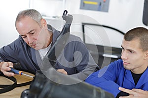 apprentice mechanic holding engine block