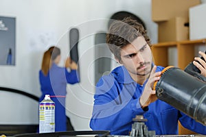 Apprentice mechanic working on auto part