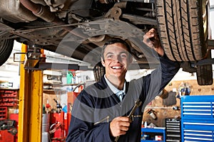 Apprentice Mechanic Working On Car