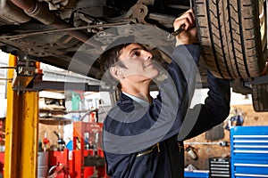 Apprentice Mechanic Working Under Car