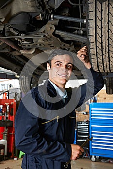 Apprentice Mechanic Working Under Car