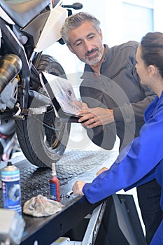 Apprentice motorbike mechanician with professor photo