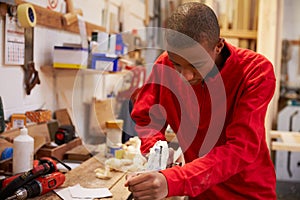 Apprentice Planing Wood In Carpentry Workshop