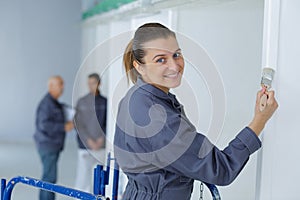 apprentice posing while painting wall