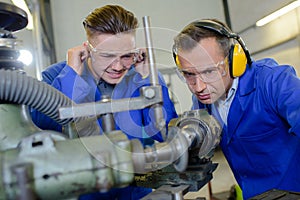 Apprentice protecting ears from noisy machine photo