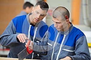Apprentice sawing piece wood