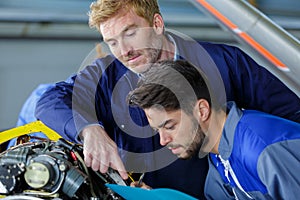 Apprentice taking notes engine parts