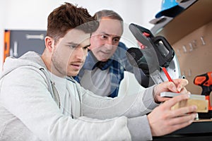apprentice and teacher in carpentry workshop