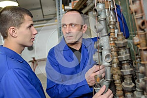 Apprentice and teacher next to gas pipes